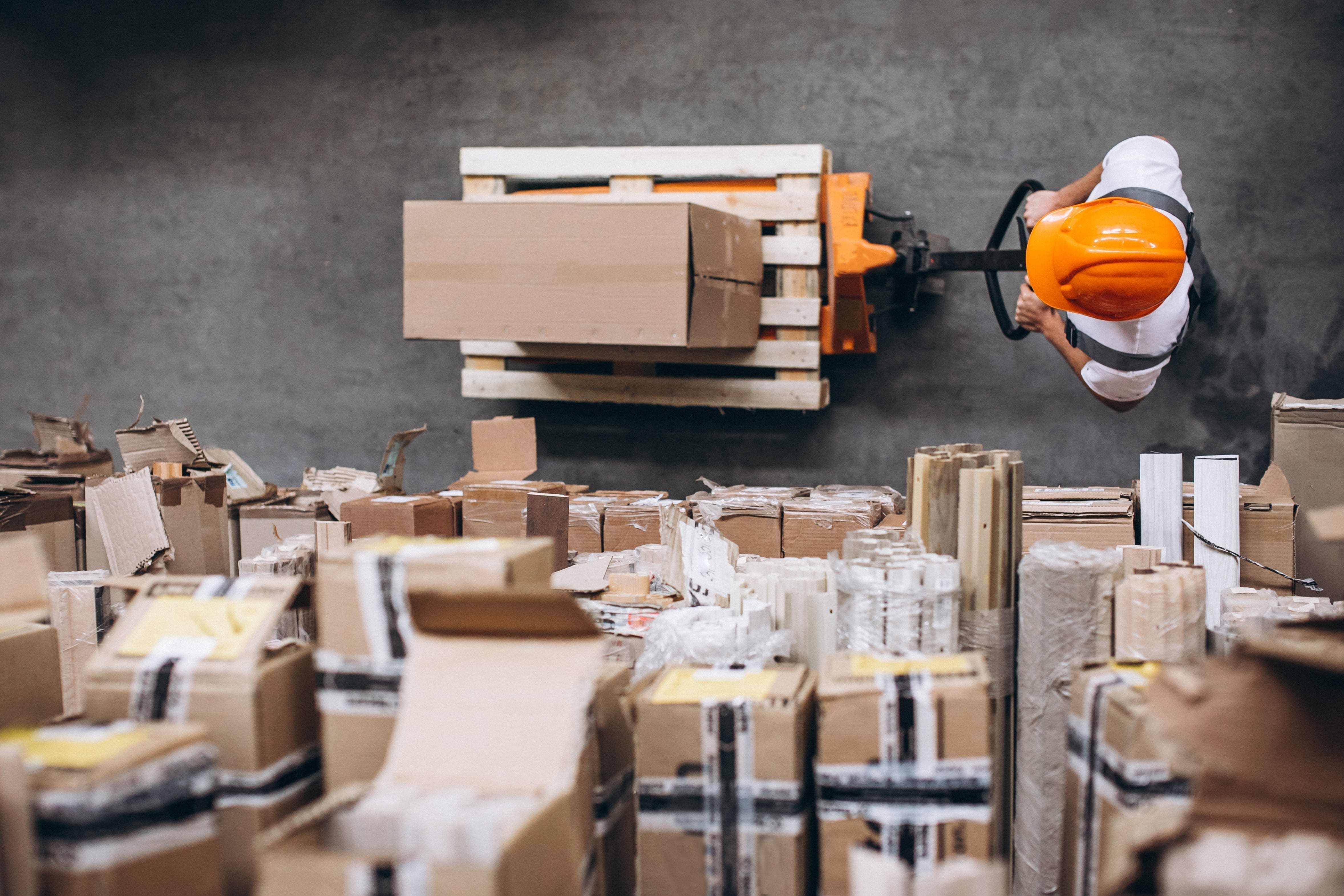 young man working warehouse with boxes - Piața spațiilor industriale și logistice din România, în competiția dezvoltării cu marii campioni regionali
